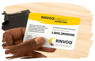 Hand holding RINVOQ Complete savings card.